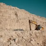 Decarbonization Pathway in the Mining Sector 4 Excavator working on a limestone quarry face