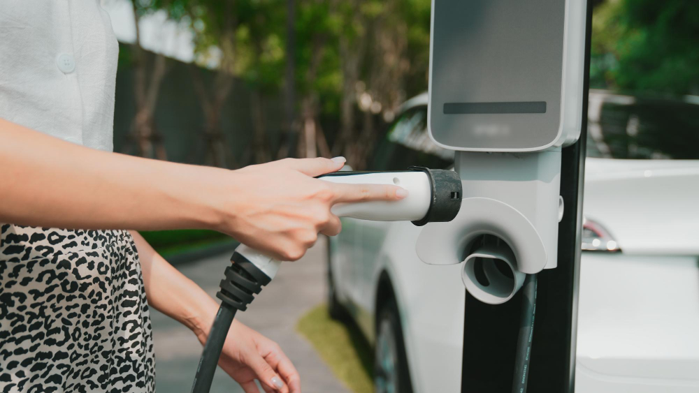 EVolve: Driving the EV Transition With Carbon Credits 1 Person plugging an EV charging cable into a white car