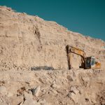 Decarbonization Pathway in the Mining Sector 3 Excavator working on a limestone quarry face