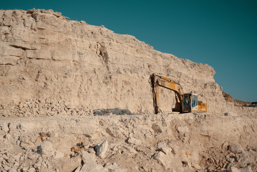 Excavator working on a limestone quarry face